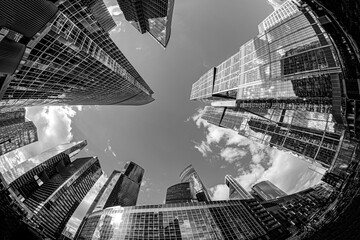 Black and white image looking up at tall, glass skyscrapers in Moscow with a fisheye lens; concept...