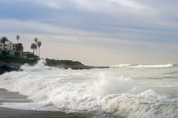 2023-12-31 ROUGH WAVES CRASHING ON THE SHORE IN LA JOLLA DURING A STORM WITH THE SHORELINE AND A NICE SKY NEAR SAN DIEGO CALIFORNIA