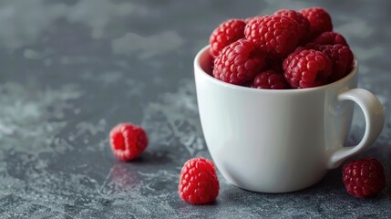 Ripe raspberries in a bowl on a gray background, juicy berries, vitamins.
