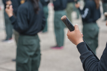 Female riot police practice using batons to control crowds.
