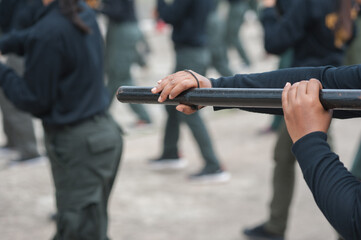 Female riot police practice using batons to control crowds.
