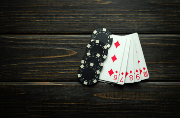 A combination of straight flush cards and winning chips on a black vintage table. Low key concept of large winning combination in a poker club - obrazy, fototapety, plakaty