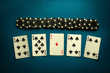 Chips and playing cards with a winning high card combination on a blue table. Concept of luck or...