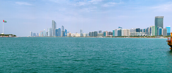 Panoramic view of Abu Dhabi city with sea, skyscrapers from waterfront Corniche in United Arab Emirates