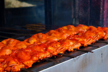 A row of middle east food of chicken satay skewers being grilled on a grill.