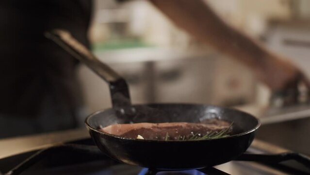 Close up of a chef cooking octopus in a hot pan. Gastronomic french restaurant