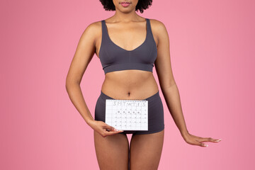 Young woman holding a period calendar - obrazy, fototapety, plakaty