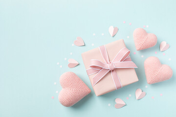 Birthday, Woman or Mothers Day greeting card. Pink hearts and gift box on blue pastel table top view. Flat lay. - 779023059