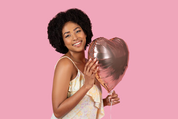 African American woman hugging a heart-shaped balloon lovingly