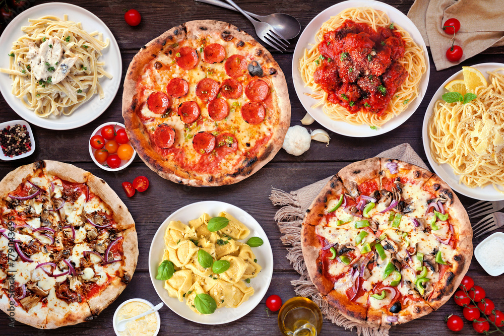 Wall mural Delicious Italian food table scene. Assortment of pizzas and pastas. Top view on a dark wood background. - Wall murals
