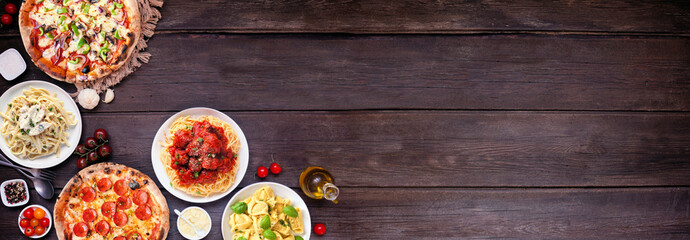 Delicious Italian food corner border. Assorted pizzas and pastas. Above view on a dark wood banner background. Copy space.