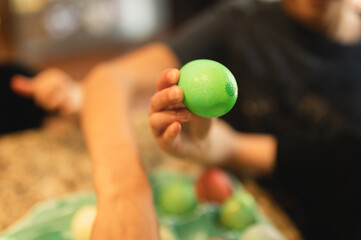 Child's hand holding dyed Easter egg, Easter tradition concept