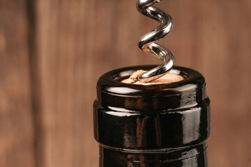 Close-up shot of a metal corkscrew pulling out a wine cork with plenty of copy space. This image is...