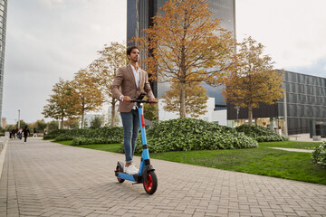 Businessman driving electric scooter in the city