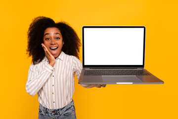 Excited woman presenting laptop with blank screen