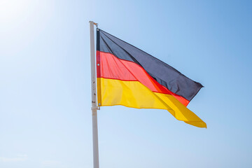 Flag of Germany on blue sky background.