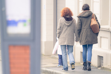 Couple de deux femmes vues de dos marchant dans la rue