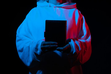 Person holding a black book with blue and red lighting