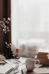 Aesthetic home office desk corner with cup of coffee or tea, white and brown background with copy space, brown academia