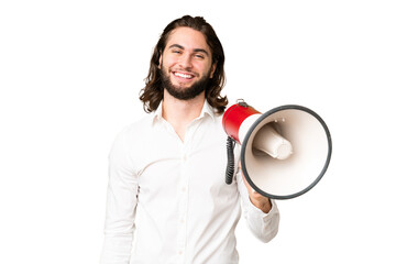 Young handsome man over isolated chroma key background holding a megaphone and smiling a lot