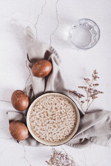 Naturally colored Easter eggs, plate, cutlery and glass of water on the table top and vertical view