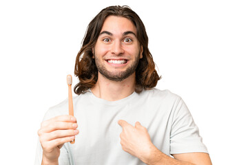 Young handsome man brushing teeth over isolated background with surprise facial expression - 779062633