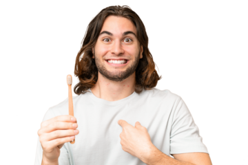 Young handsome man brushing teeth over isolated background with surprise facial expression