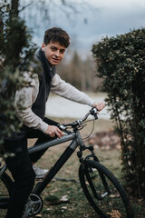 Fototapeta premium Outdoor shot of a young male teenager on a bicycle, looking relaxed and happy during a casual ride in a natural setting.