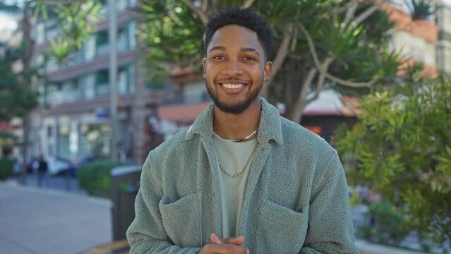 African american man smiling in urban outdoor setting, casual style, daylight, city