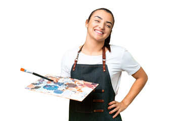 Young artist woman holding a palette over isolated chroma key background posing with arms at hip...