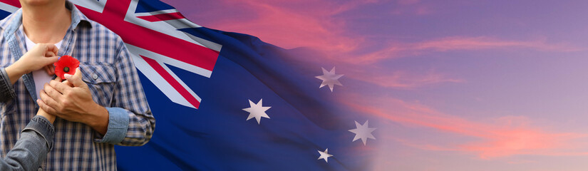 Anzac is the Australian national holiday. Hands with poppy buds on national flag background. 3d illustration