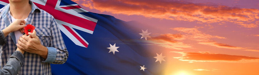 Anzac is the Australian national holiday. Hands with poppy buds on national flag background. 3d illustration