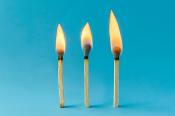 Three matchsticks are lit and are leaning on each other