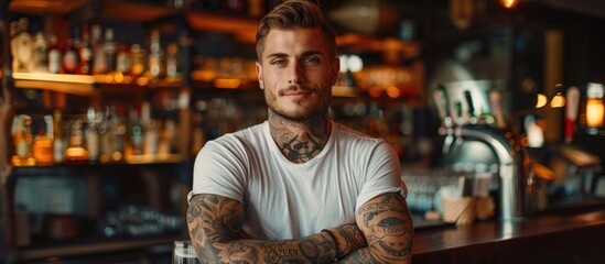 A confident young man with tattoos standing in front of a bar, exuding a strong presence against the bar backdrop.