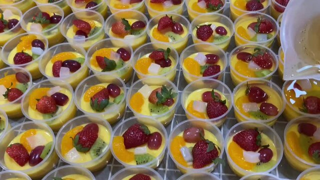 Home industry catering makes healthy mango milk pudding. Puddings are made from mango juice and milk. Topping: vanilla jelly, strawberry, grape, kiwi, mandarin orange, and nata de coco (coconut gel).