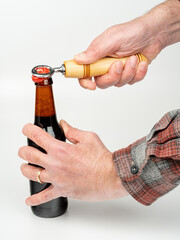 Man opening a bottle of dark beer