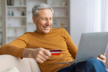 Elderly man shopping online with credit card