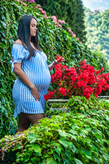 Gorgeous pregnant South American girl, wearing a long striped shirt