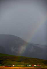 A rainbow above the rural hamlet of Hof at sunset, right by the Ring Road (Route One), on the south coast of Iceland.