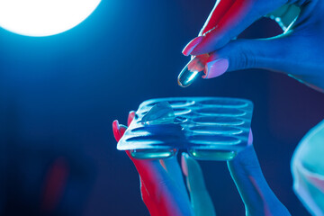 hand takes a pill out of the package close-up in ultraviolet color