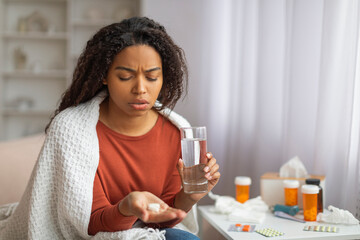 Young Black Woman Taking Medication at Home During Daytime