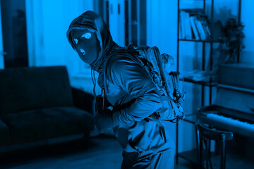 Hooded figure of man in blue monochrome ambience