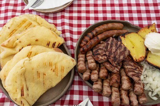 Mixed platter of meat with Cevapcici, sausages and pleskavica served in local restaurant in Maribor, Slovenia. Served with potatoes, onions and pita bread. National dish in traditional shop