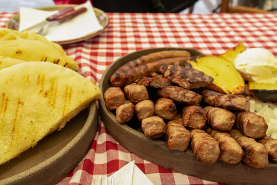 Mixed platter of meat with Cevapcici, sausages and pleskavica served in local restaurant in Maribor, Slovenia. Served with potatoes, onions and pita bread. National dish in traditional shop