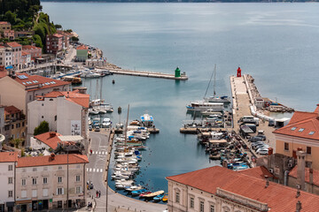 Scenic aerial view of harbor in coastal town Piran, Primorska, Slovenia, Europe. Shimmering azure waters of Adriatic Sea. Tranquil Mediterranean atmosphere. Exploring Slovenian Coast in Istria