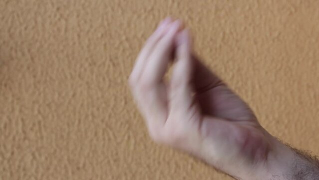 Male hand wobbling performing Mamma Mia italian hand sign