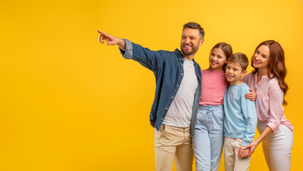 Father pointing and leading family on yellow