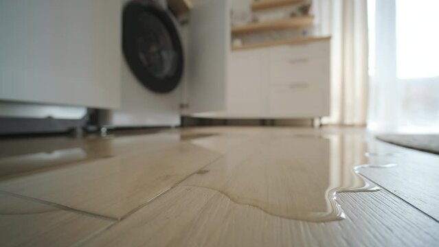 Water leaking from a washing machine in a contemporary kitchen setting