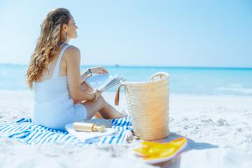 relaxed modern woman on seacoast with straw bag