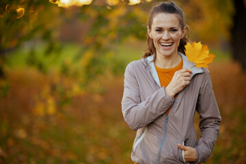 Portrait of happy elegant female in fitness clothes in park